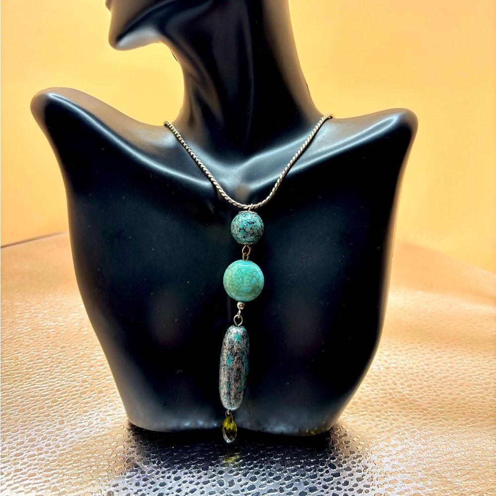 A 35” turquoise tone statement necklace with matching earrings